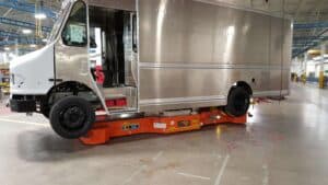 Orange Automatic Guided Vehicle with a box truck on it.