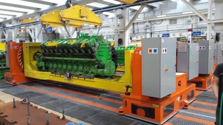 Green and yellow custom work positioners in an industrial setting with electrical cabinets.