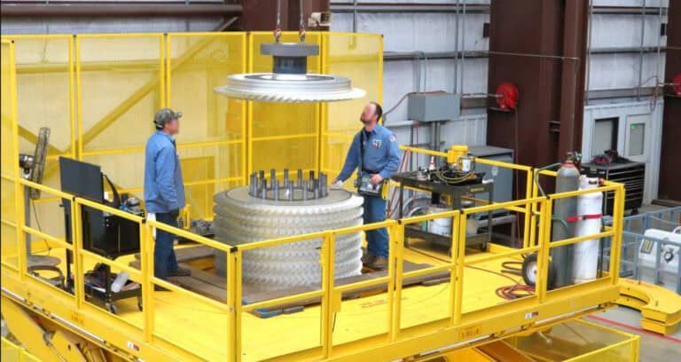 Workers operate machinery using yellow vertical assembly solutions in an industrial setting.