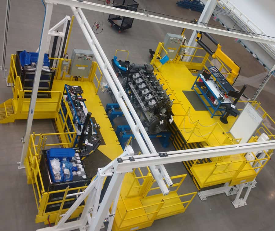 Aerial view of a yellow industrial platform with machinery and workstations in a manufacturing facility.